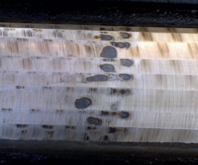 Dark burn spots visible on a ground railhead surface — the visual evidence inspectors look for